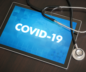 Stethoscope laying on top of ipad that says COVID-19.