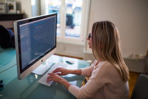 Women sitting at desk working on computer.