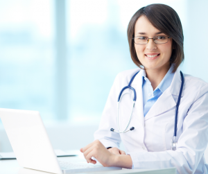 Doctor sitting in front a a laptop.