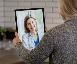 Lady sitting in front of ipad talking to her doctor online.